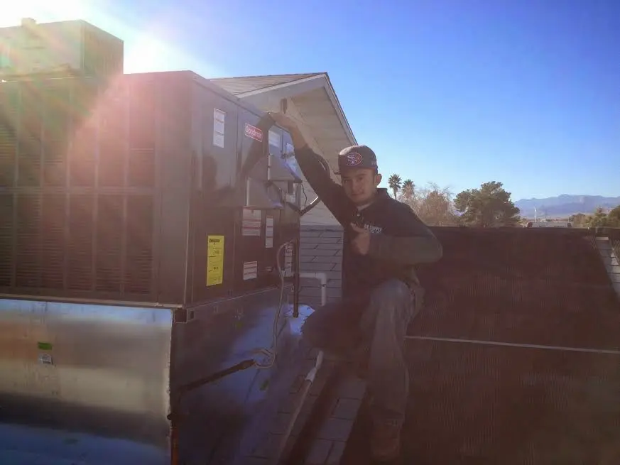 HVAC technician performing Air Duct Cleaning on a rooftop unit in Carroll